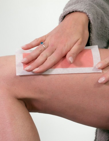 Ragazza che applica una striscia depilatoria corpo Elmaris sulla coscia