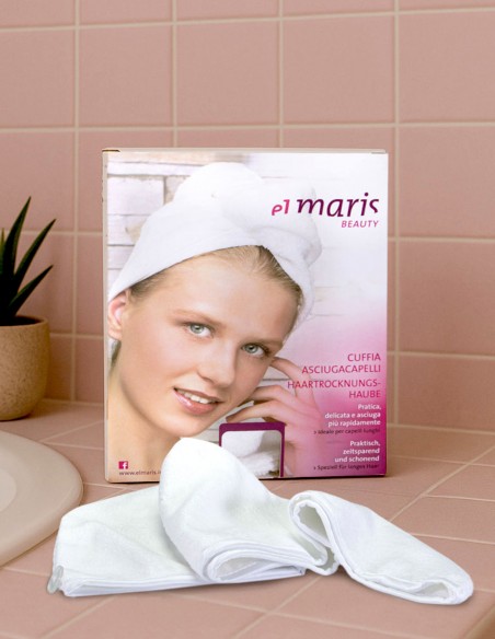 Confezione del turbante asciugacapelli appoggiata su una superficie del bagno