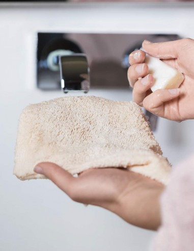 Donna che ha terminato di lavare il guanto struccante con acqua e sapone