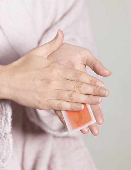 Donna che scalda due strisce depilatorie per sopracciglia tra le mani