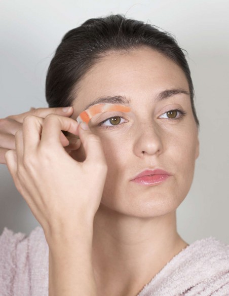 Ragazza che sistema la striscia depilatoria lungo il suo arco sopraccigliare