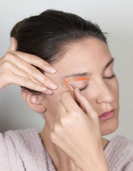 Donna che strappa la striscia depilatoria con un colpo secco e deciso