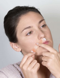 Ragazza che applica una striscia depilatoria per baffetti facendola aderire bene alla pelle