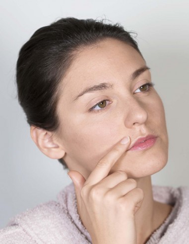 Donna che applica un olio lenitivo sulla parte appena depilata