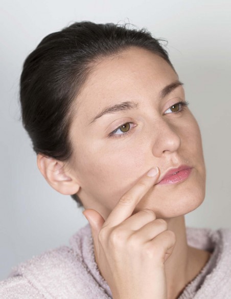 Donna che applica un olio lenitivo sulla parte appena depilata Donna che applica un olio lenitivo sulla parte appena depilata