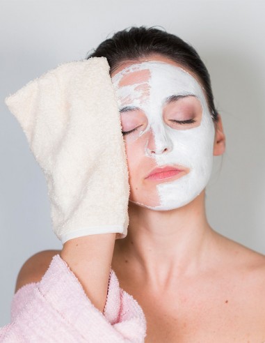 Ragazza che rimuove una maschera viso usando il guanto struccante