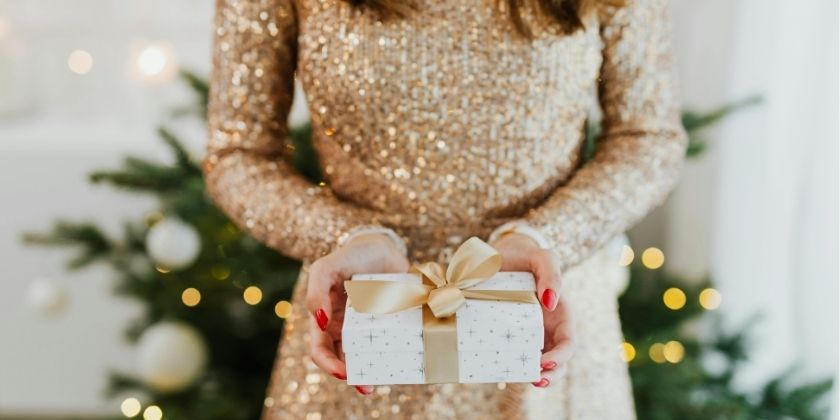 Donna che porge un regalo di Natale